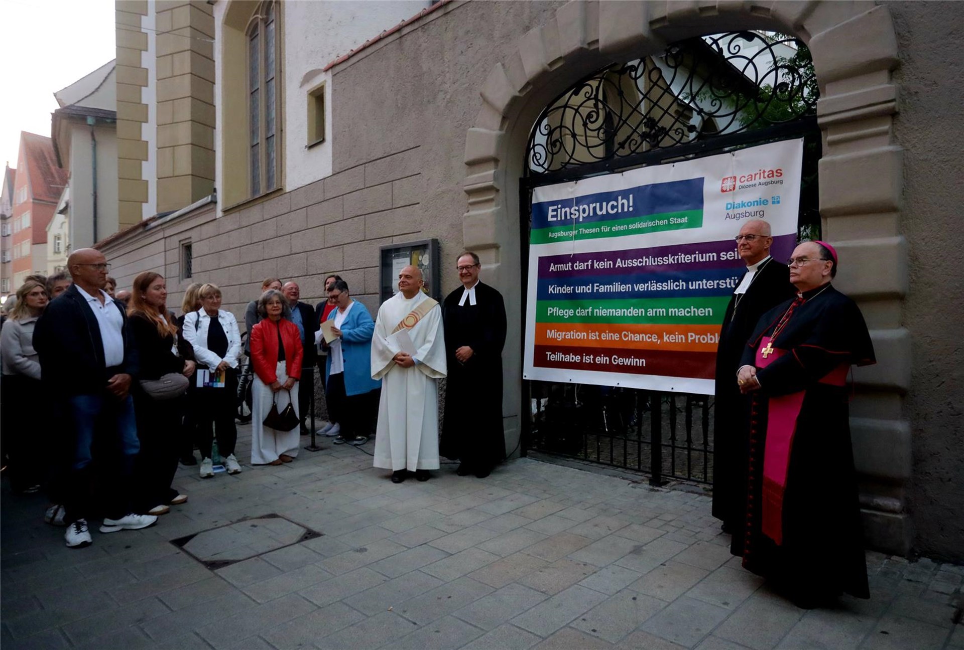 Mit dem Augsburger Thesenanschlag bei der evangelischen Annakirche an der Annastraße stellen (v.re.n.li.) der katholische Bischof Dr. Bertram Meier, der evangelische Regionalbischof Klaus Stiegler, der theologische Vorstand der Diakonie Augsburg, Pfarrer Fritz Graßmann, und der Augsburger Diözesan-Caritasdirektor Richtlinien und Forderungen für einen solidarischen Staat auf, die – wenn der Staat Gerechtigkeit üben und Solidarität bewahren wolle – grundlegend für künftige Sozialreformen sind. 