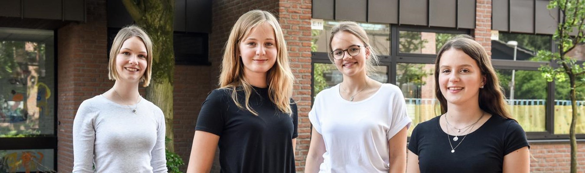 Vier junge Frauen blicken in die Kamera